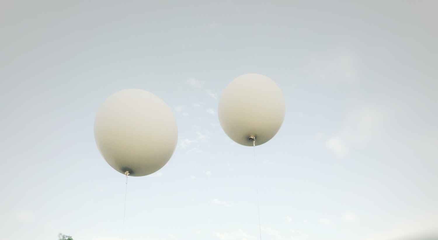 Weiße Ballons vor blauem Himmel