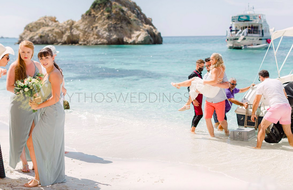 Braut wird auf Händen zum Strand Fteri getragen