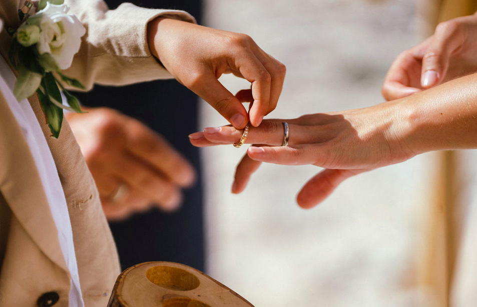 Frauenhand wird Ring angesteckt