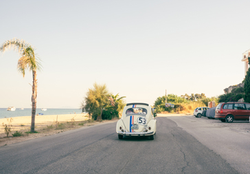 VW Käfer an einer Küstenstrasse in Griechenland