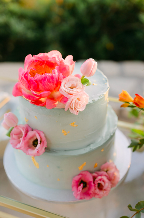Weiße wezistöckige Hochzeitstorte mit pinkfarbenen Blumen