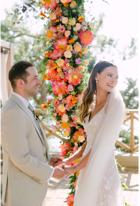 Brautpaar vor Blumengirlande in pink
