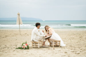 Hochzeitspaar auf Hockern am Strand in Griechenland