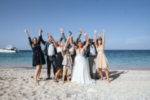 Hochzeitsgesellschaft feiert am Strand mit Braut in der Mitte